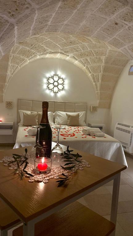 a room with a bed with a table with a bottle and candle at Samy Suite in Fasano