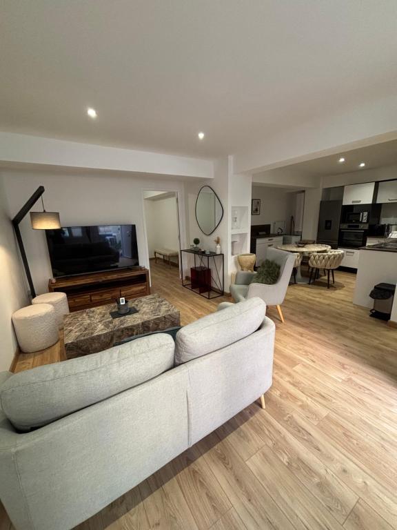 a living room with a white couch and a television at Appartement Ajaccio T3 in Ajaccio