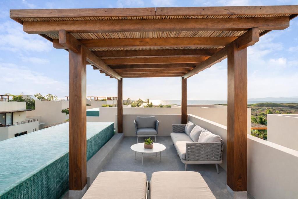 an outdoor patio with a pergola and the water at Casita VR08 in Zihuatanejo