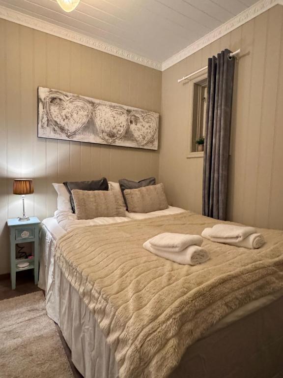 a bedroom with a large bed with two towels on it at Trollveggen in Åndalsnes