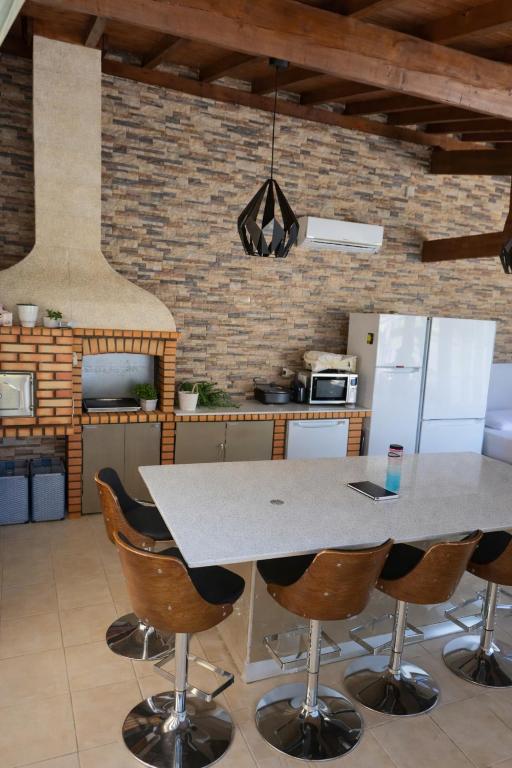 a kitchen with a table and chairs at Casa 3 quartos - Outeiro do Sul in Adopisco