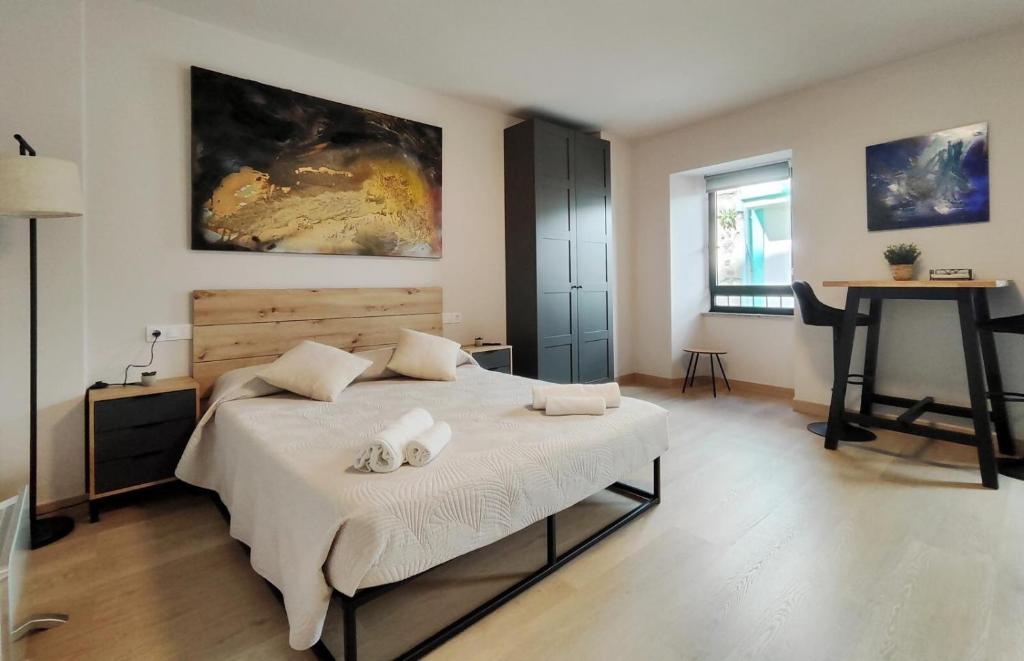 a bedroom with a bed with two towels on it at Elite Muralla Lugo Experience 2.1 in Lugo