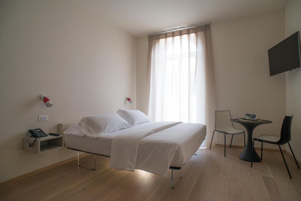 a white bedroom with a bed and a window at Verona Design in Verona