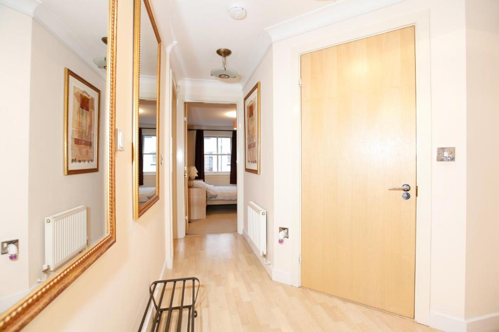 a hallway with a wooden door and a chair at Leamington Spa Apartments in Leamington Spa