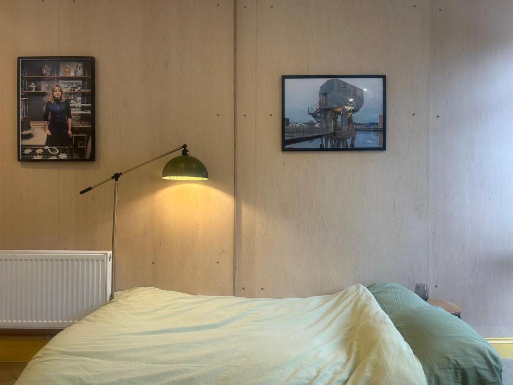 a bedroom with a bed and a lamp and pictures on the wall at Sauna Haus in Brighton & Hove