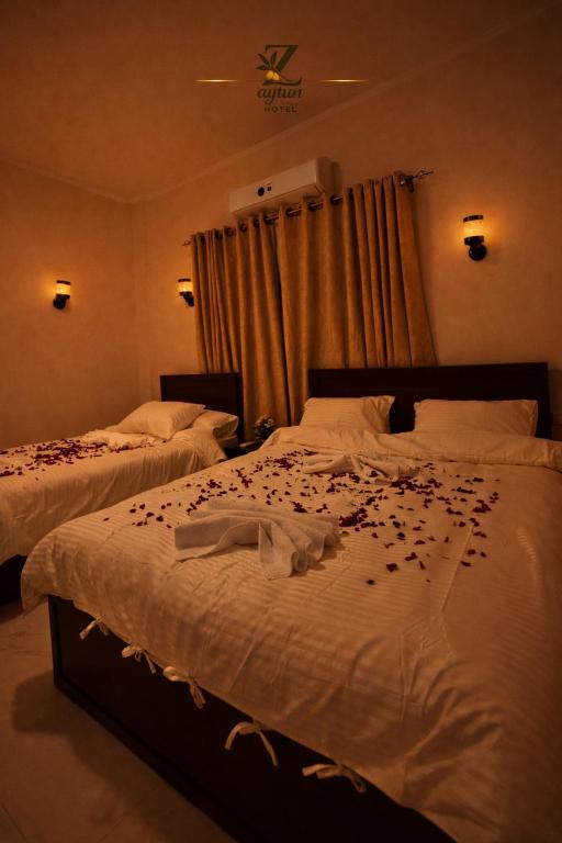 a bedroom with two beds with flowers on the sheets at Zaytun Hotel Dahab in Dahab