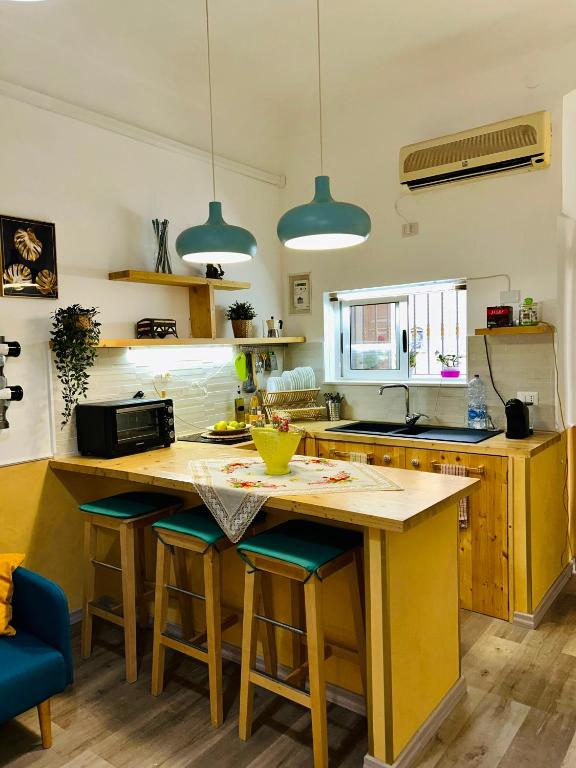 a kitchen with a yellow island with bar stools at La Corte di Noto in Noto