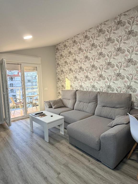 a living room with a couch and a table at Central Suites Silgar Sanxenxo in Sanxenxo