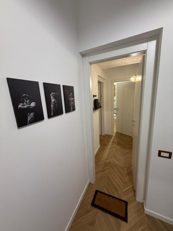a hallway with black and white pictures on a wall at Le casette apartaments in Torre Annunziata