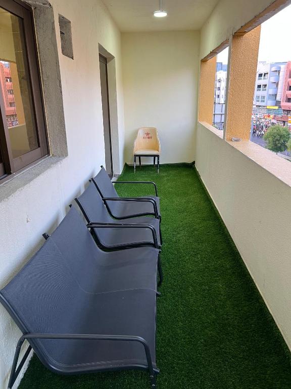 a row of chairs in a hallway with green grass at United Holiday Homes in Dubai