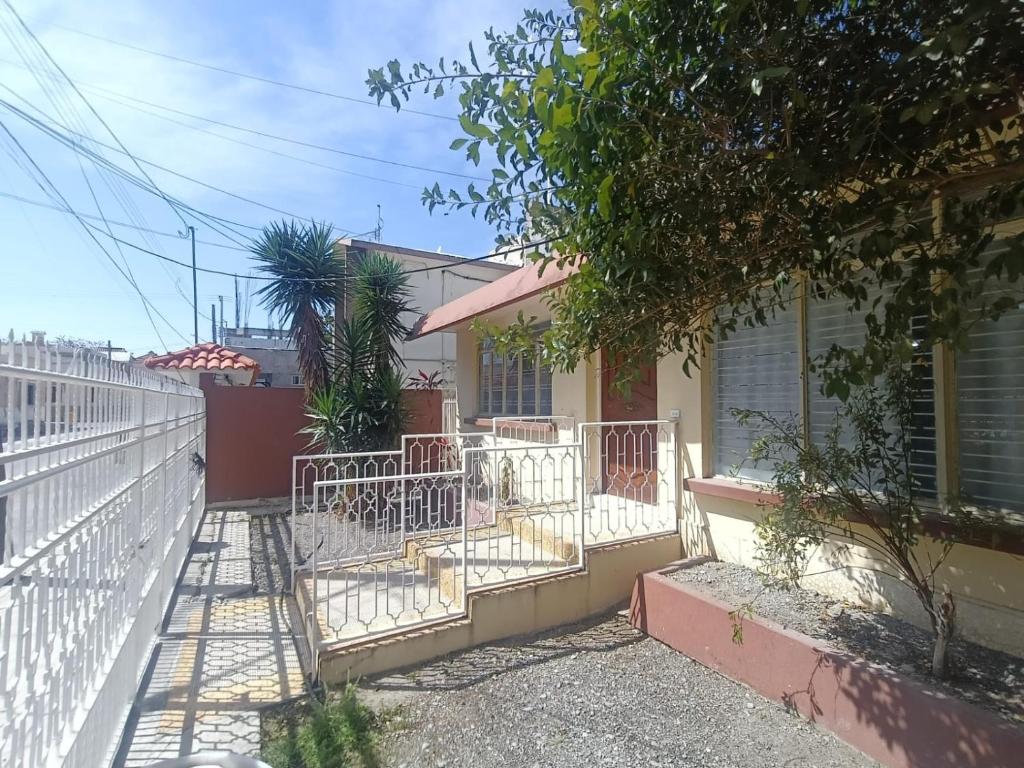 a house with a white fence in front of it at Casa Emilio Carranza, Linares in Linares