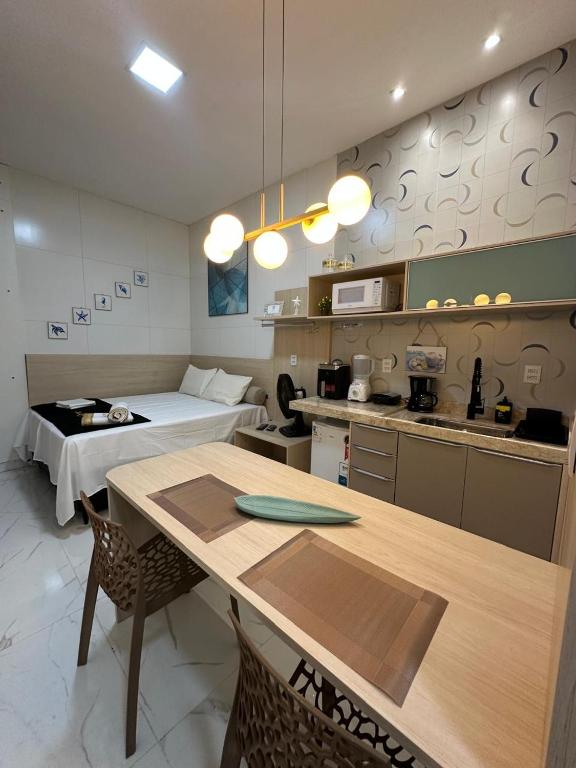 a kitchen and living room with a table and a bed at Flat jk 05 térreo in Juazeiro do Norte