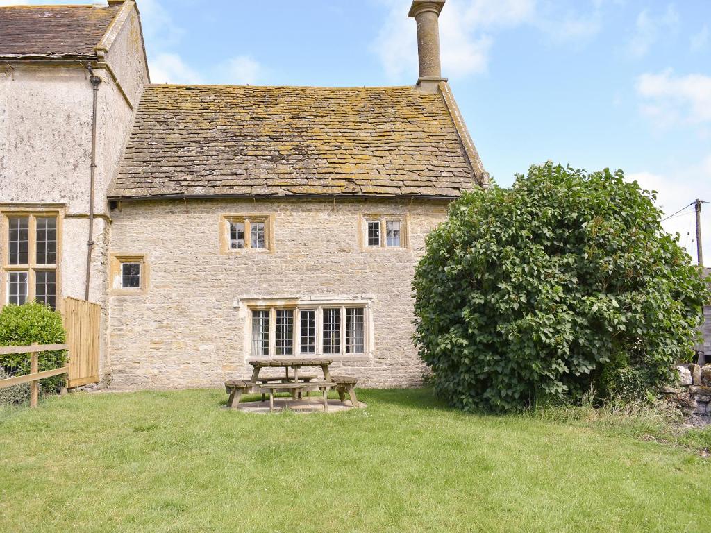 a picnic table in front of a stone building at Churchill Cottage in Wootton Glanville