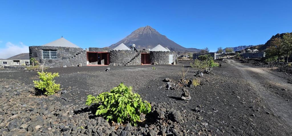 a stone building with a mountain in the background at Funco Jacó in Portela
