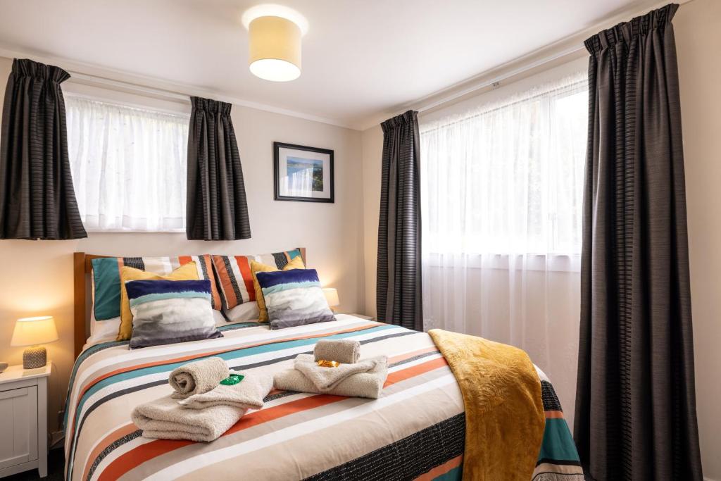 a bedroom with a bed with towels on it at The Shack in Mangonui