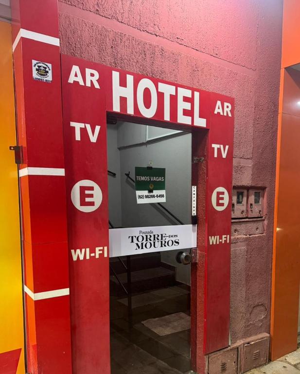 an open door to a hotel with a sign on it at Pousada Torre dos Mouros in Pirenópolis
