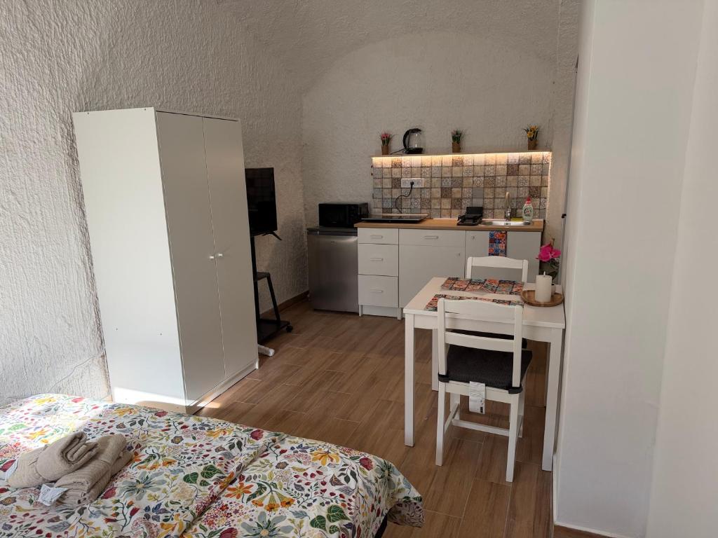 a room with a bed and a table and a kitchen at La Casa de Nido-Cozy Studio in Veszprémfajsz
