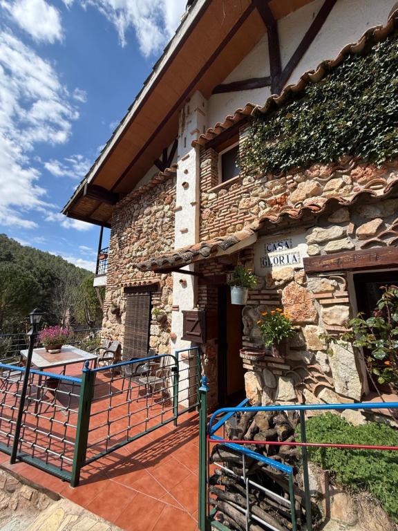 un edificio in pietra con un cancello di fronte di Paraje el Serbal a Benatae