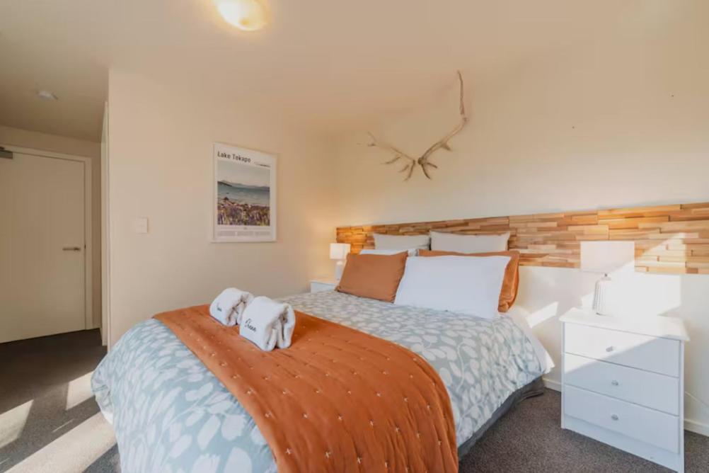 a bedroom with a bed with two towels on it at Lake Tekapo Cottages in Lake Tekapo