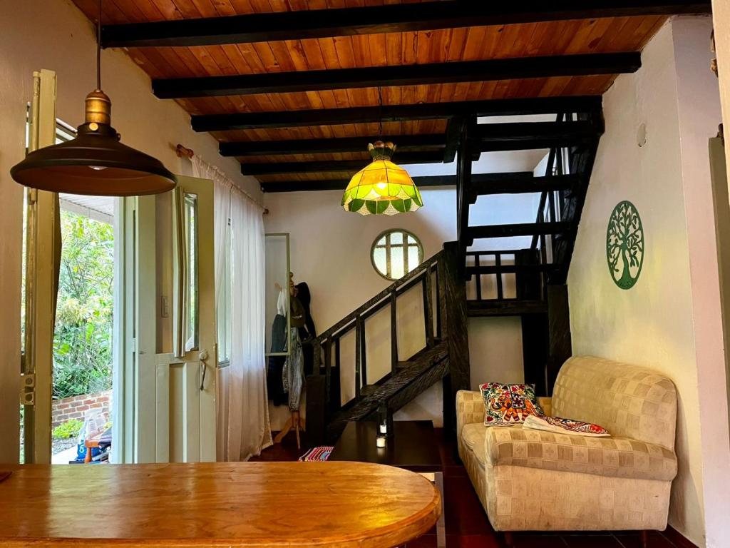 a living room with a table and a spiral staircase at Tu Refugio en el Campo in San Francisco
