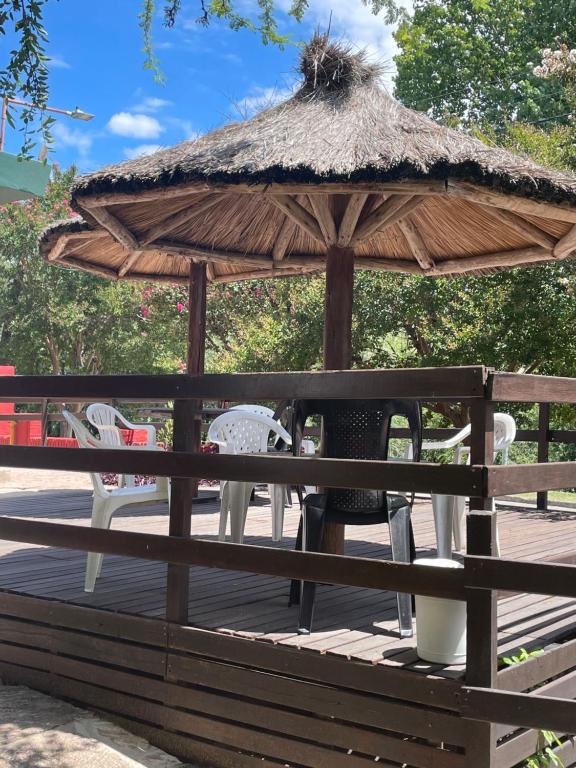 a wooden table with a umbrella and chairs at CASONA Malva del Rio in Villa Carlos Paz