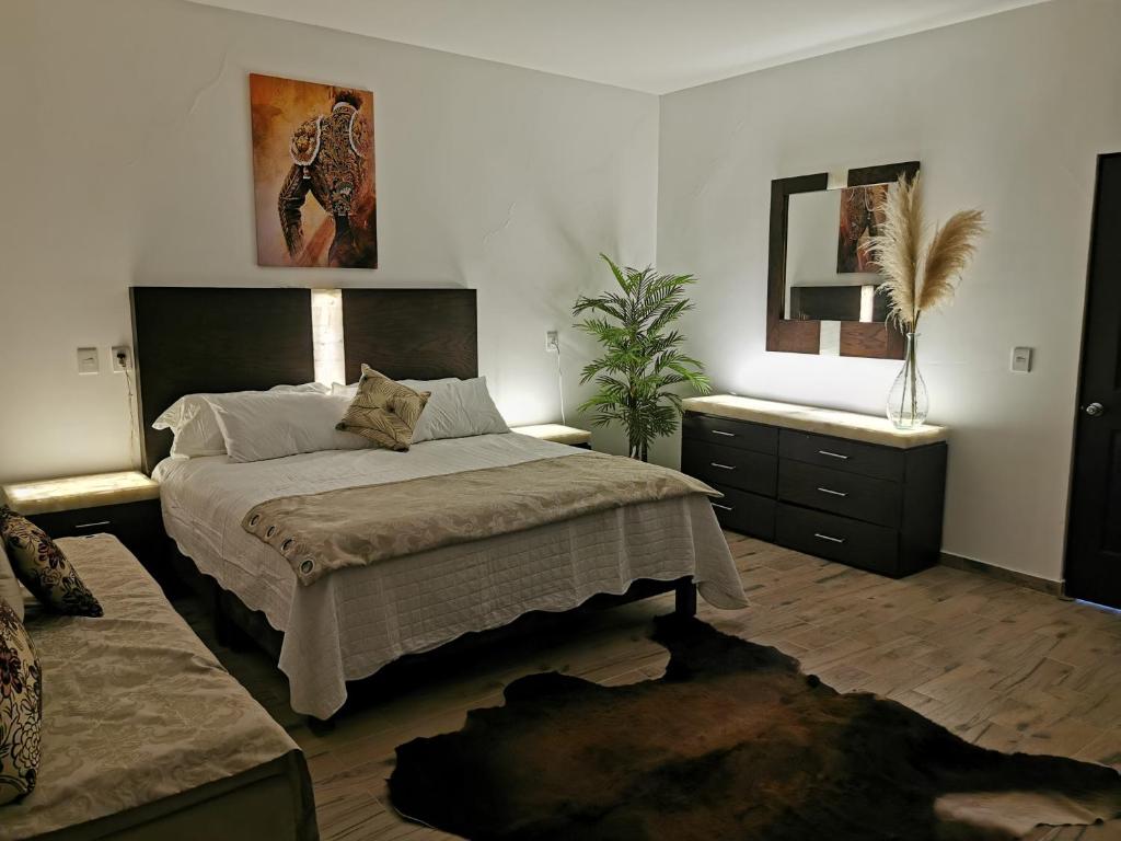 a bedroom with a large bed and a mirror at San Carlo hotel in Guanajuato