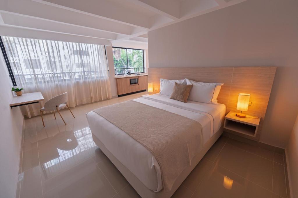 a hotel room with a large bed and a window at Alcaré Rooms Cartagena in Cartagena de Indias