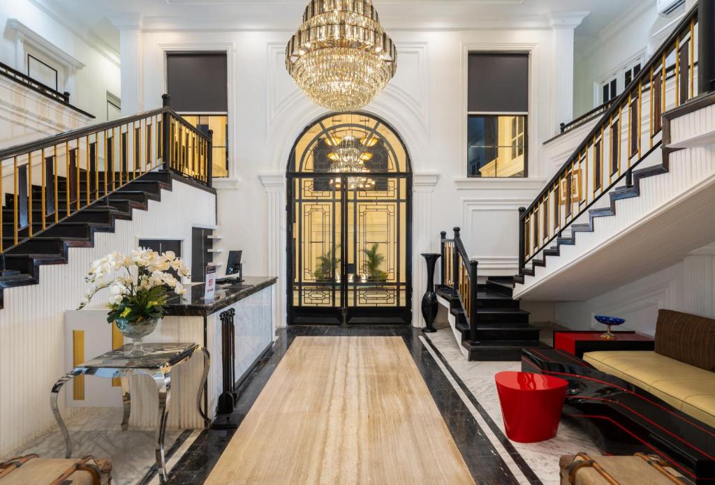 a living room with stairs and a chandelier at Swiss-Belexpress Palu in Palu