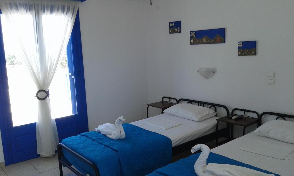 a bedroom with two beds and a window at Vigles in Adamantas