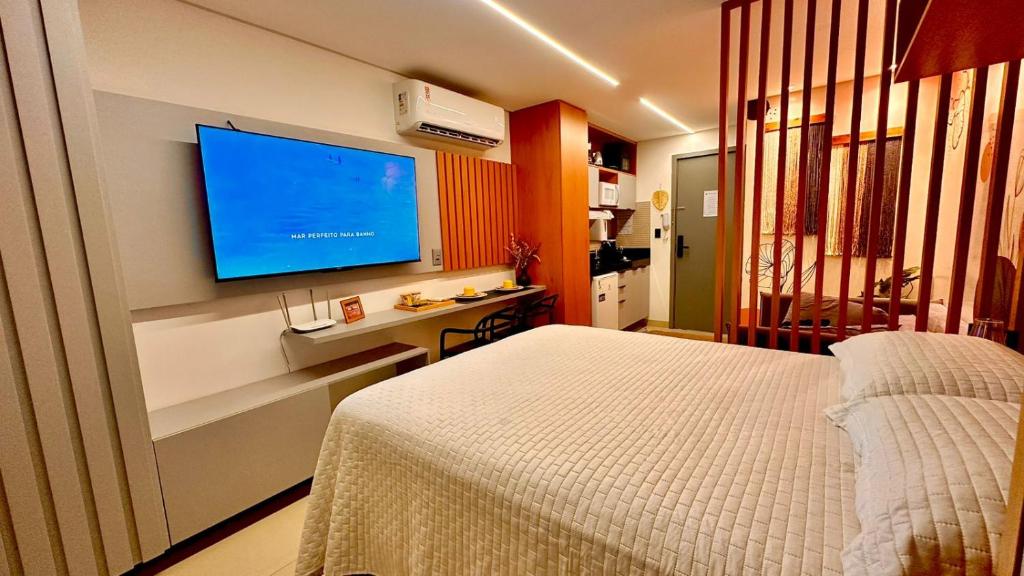 a bedroom with a bed and a flat screen tv at Flat com acesso rápido as praias e o melhor do turismo local in João Pessoa