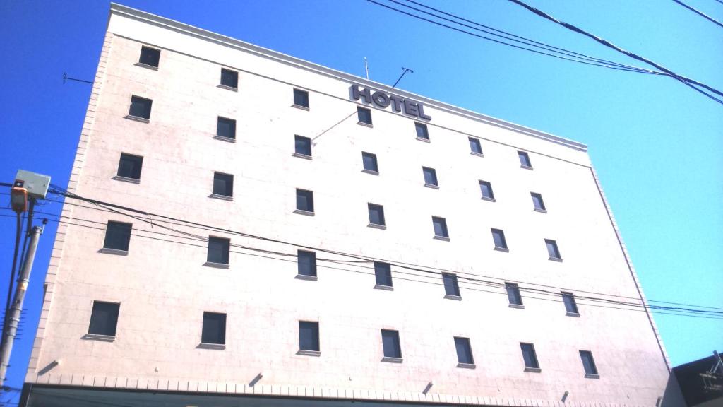 a tall white building with a sign on it at Dom Quixote São Gonçalo Hotel in São Gonçalo