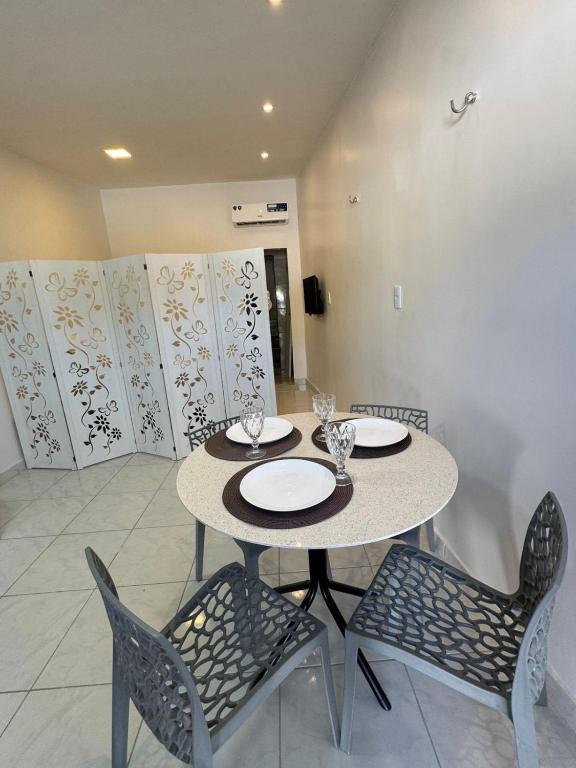a dining room with a table and two chairs at Casa aconchego do pontal in Fortim