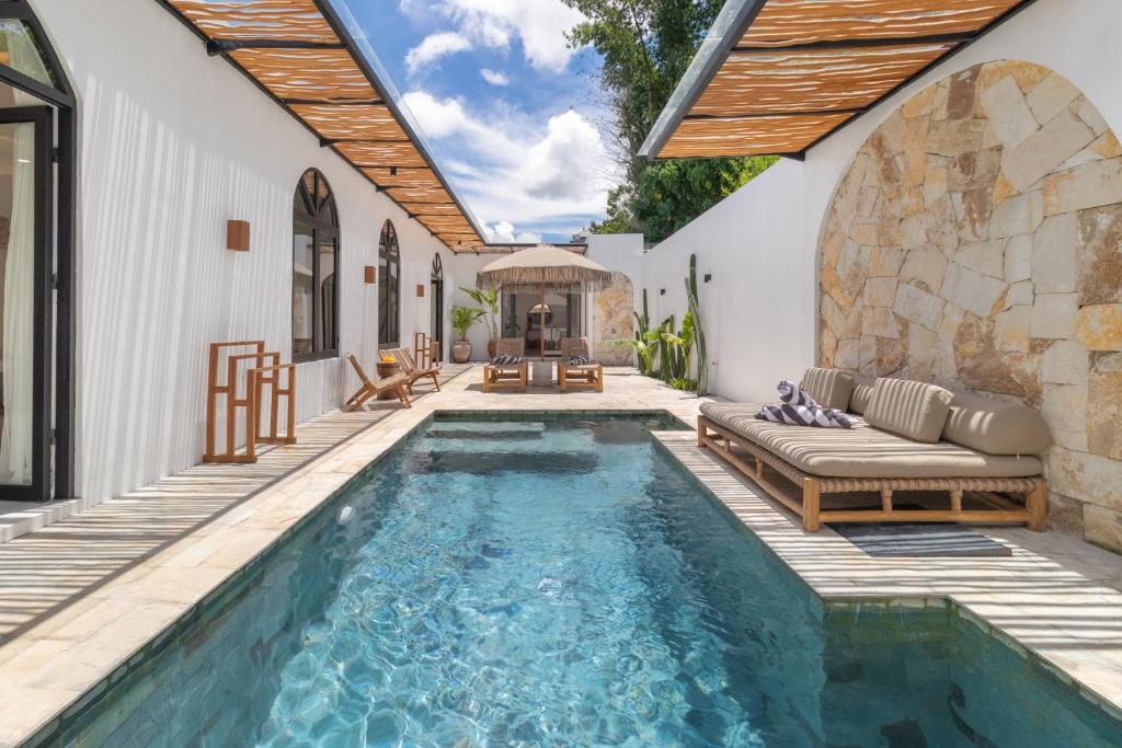 an outdoor swimming pool with a patio and a house at Chic 2BR Private Pool Villa in Canggu in Dalung