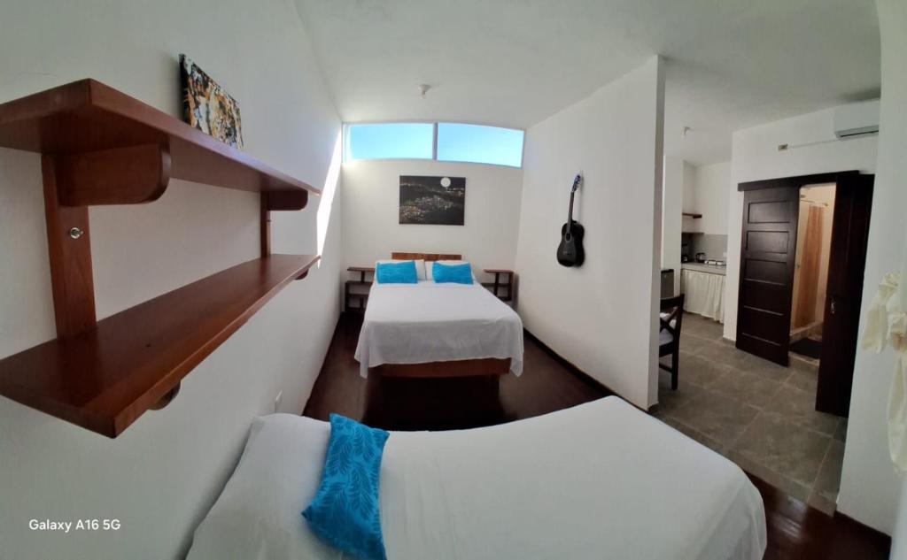 a hotel room with two beds and a window at Pescadito in Puerto Ayora