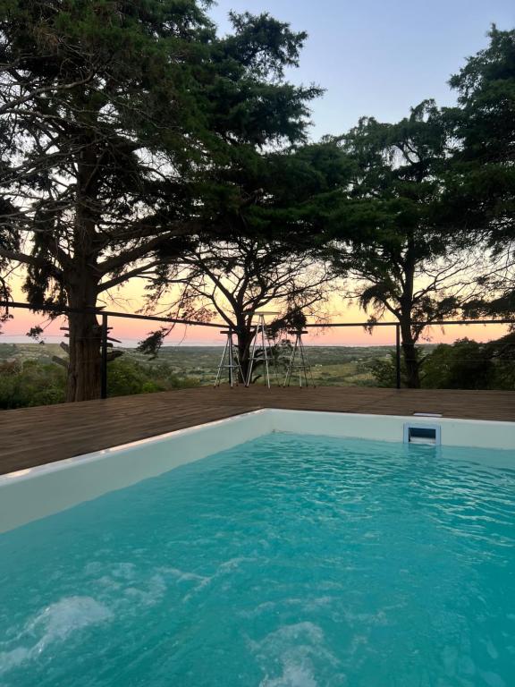 a swimming pool with a sunset in the background at NuestroSueño in Villa Serrana
