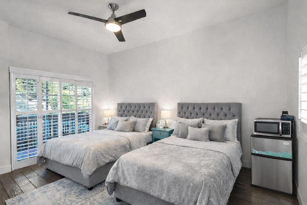 a bedroom with two beds and a ceiling fan at Modern Hillside 1BR Retreat in Woodland Hills