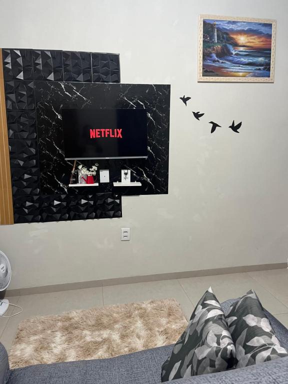 a wall with a tv and birds on it at Apartamento Aconchego II in Alta Floresta