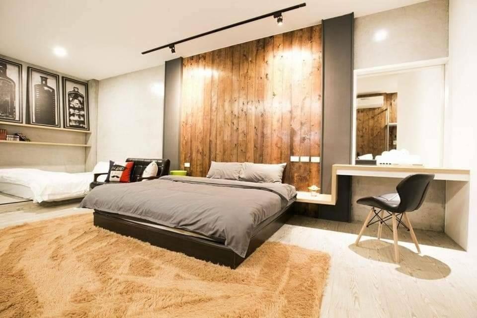 a bedroom with a large bed and a chair in it at Original Bnb in Tainan