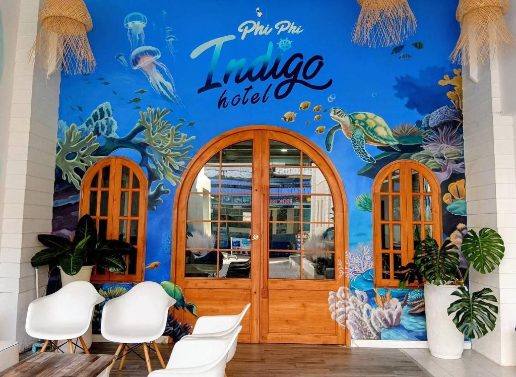 a restaurant with a blue wall with a mermaid mural at Phi Phi Indigo Hotel in Phi Phi Islands