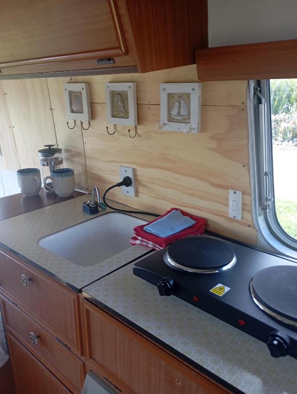 a kitchen with a sink and a counter top at Cosy Caravan in Takaka