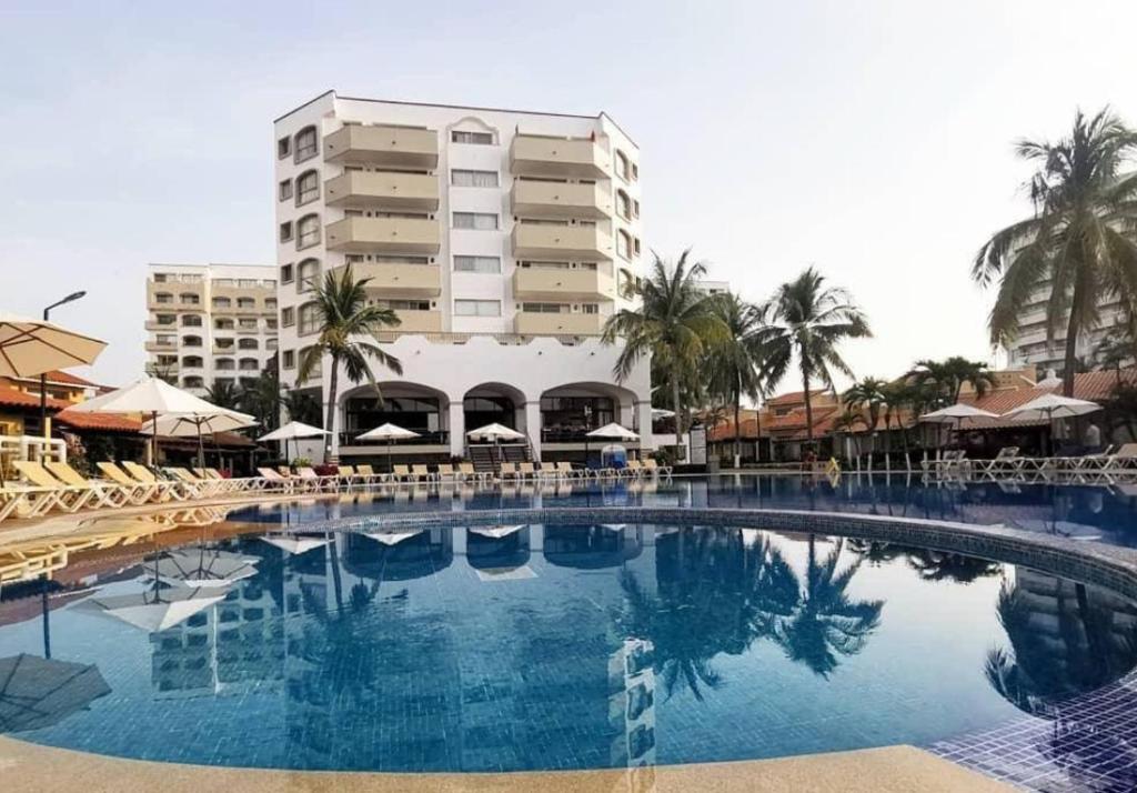 a large swimming pool in front of a hotel at Condominios Torre Continental Ixtapa in Ixtapa