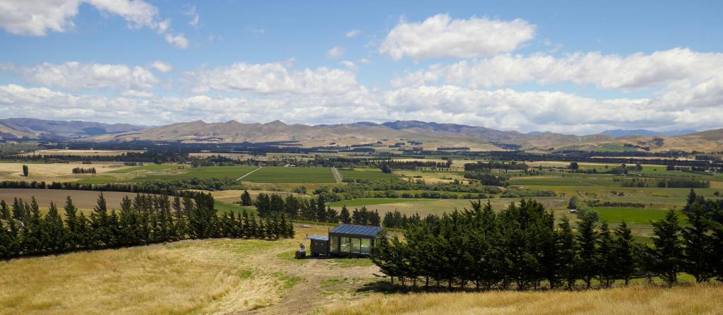 a view of a farm with a house in a field at Greystone PurePod in Waipara