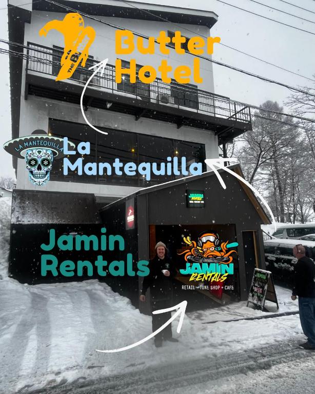 a man standing outside of a hotel in the snow at Butter Hotel in Otari