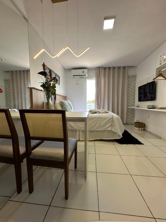a living room with a table and chairs and a bed at Flat JK 203 in Juazeiro do Norte