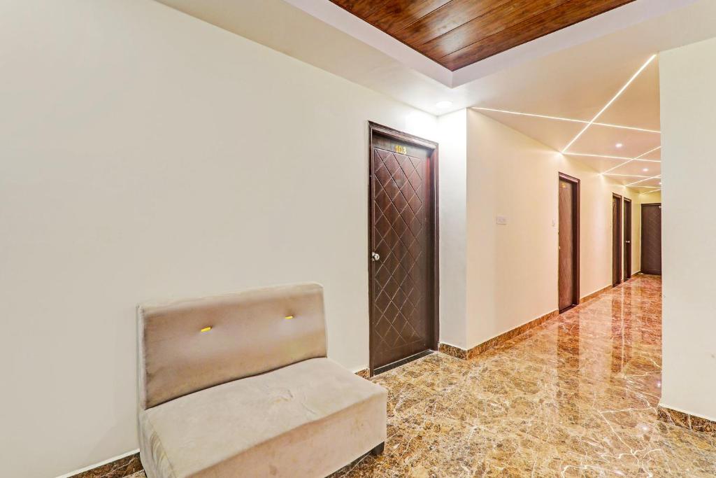 a room with a chair and a door at Super Hotel O Kathauta Jheel Malhaur Gomti Nagar in Lucknow