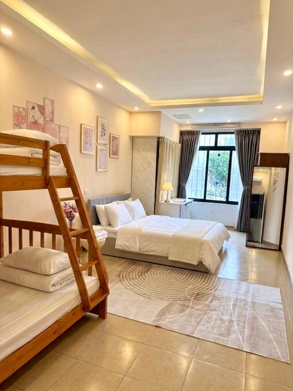 a bedroom with two beds and a large window at Hanoi Amie Duplex Homestay in Hanoi