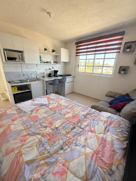 a large bed in a room with a kitchen at Private Loft Free Parking Pet friendly in Chapulco