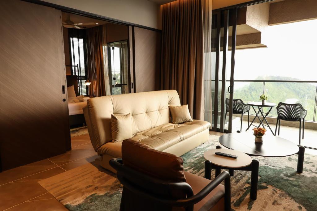 a living room with a couch and a table at Antara Genting Cozy Studio in Genting Highlands