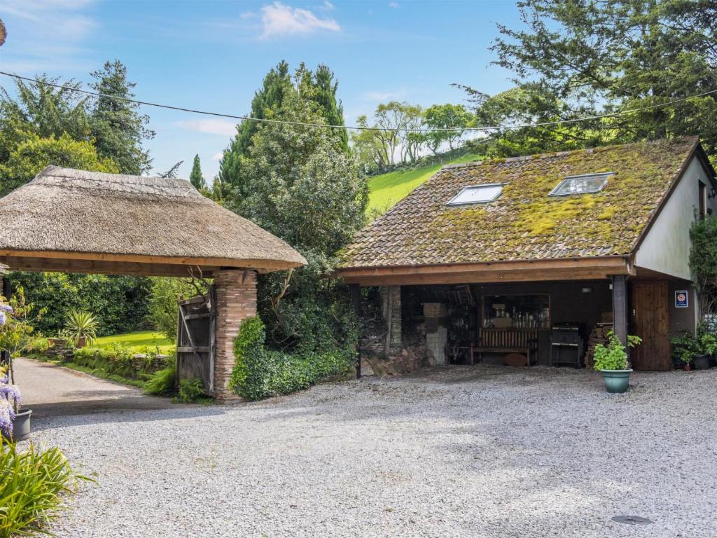 a cottage with a thatched roof and a driveway at Bilbrook- Ukc4913 in Timberscombe