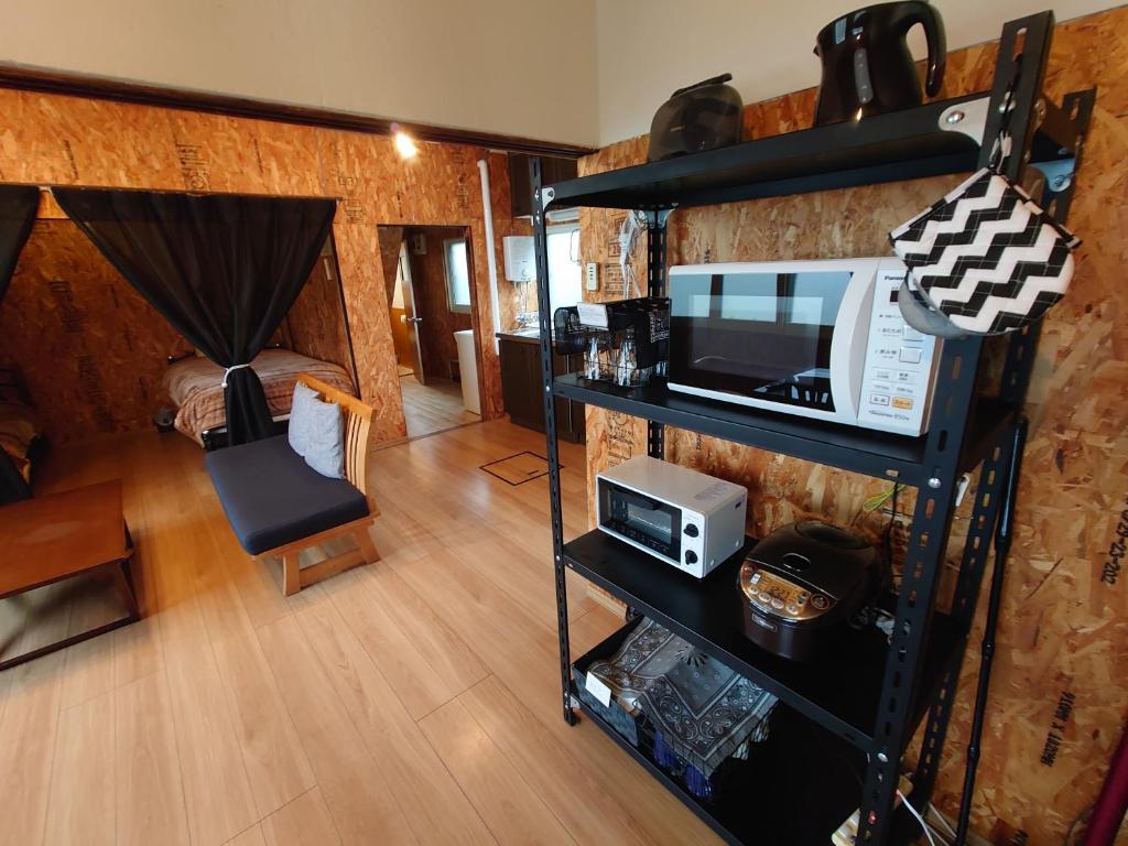 a living room with a microwave and a room with a couch at Rustic Modern House in Hakodate in Hakodate
